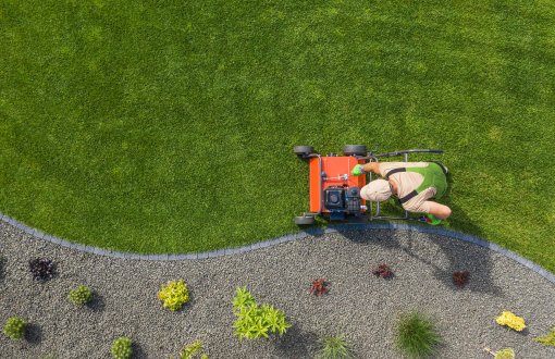 man mowing a lawn with Dark Horse landscaping services in Boca Raton south florida